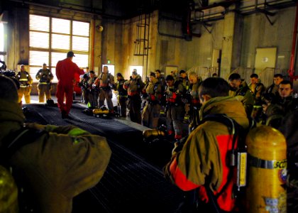 US Navy 071024-N-2638R-004 Sailors assigned to the submarine tender USS Frank Cable (AS 40), don fire fighting gear during an advanced shipboard fire fighting course at the Center for Naval Engineering's (CNE) Learning Site Yok