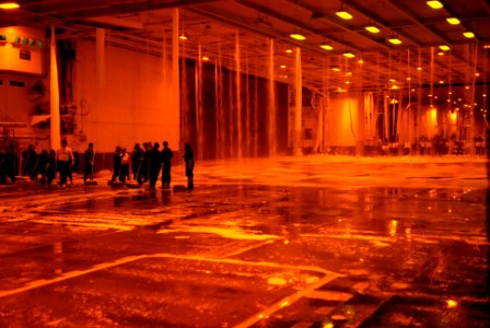 US Navy 071029-N-3659B-138 Hangar bay personnel take part in a scrub exercise as the aqueous film forming foam and countermeasure wash own sprinkler systems are tested in hangar bay one of Nimitz-class aircraft carrier USS Rona