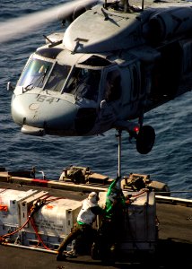 US Navy 071029-N-5928K-007 ailors aboard nuclear-powered aircraft carrier USS Enterprise (CVN 65) attach supplies to the belly of a MH-60S Seahawk