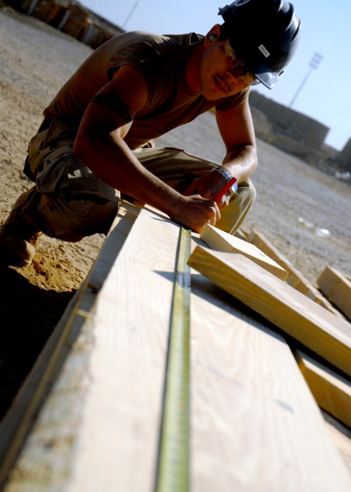 US Navy 071101-N-3857R-011 Builder Constructionman Recruit Michael High, of Naval Mobile Construction Battalion (NMCB) 1, measures out his next cut on a piece of lumber to be used in the construction of a crow's nest watch stat