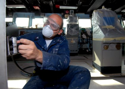 US Navy 071030-N-4399G-007 Information Systems Technician 3rd Class Nick F. Spanlopis performs grinding work in the pilothouse aboard amphibious command ship USS Blue Ridge (LCC 19)