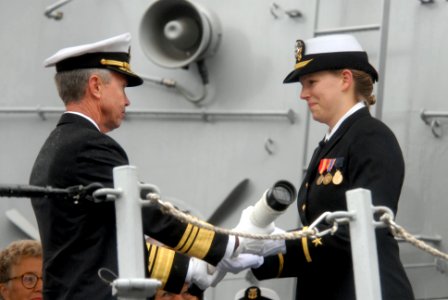 US Navy 071103-N-9909C-006 Vice Adm. William D. Sullivan hands the long glass to Ensign Christina Douglas to set the first watch aboard USS Sampson (DDG 102)