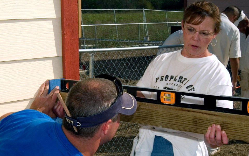 US Navy 071031-N-3750S-099 Chief Yeoman Nora Lundberg, and Lt. Cmdr. Bradley Slocum, executive officer of Navy Operational Support Center San Antonio, fit and level support beams for the porch of a Habitat for Humanity project