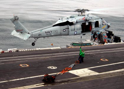 US Navy 071103-N-9898L-203 Sailors attach a hoisting cable to an MH-60S Seahawk, assigned to the