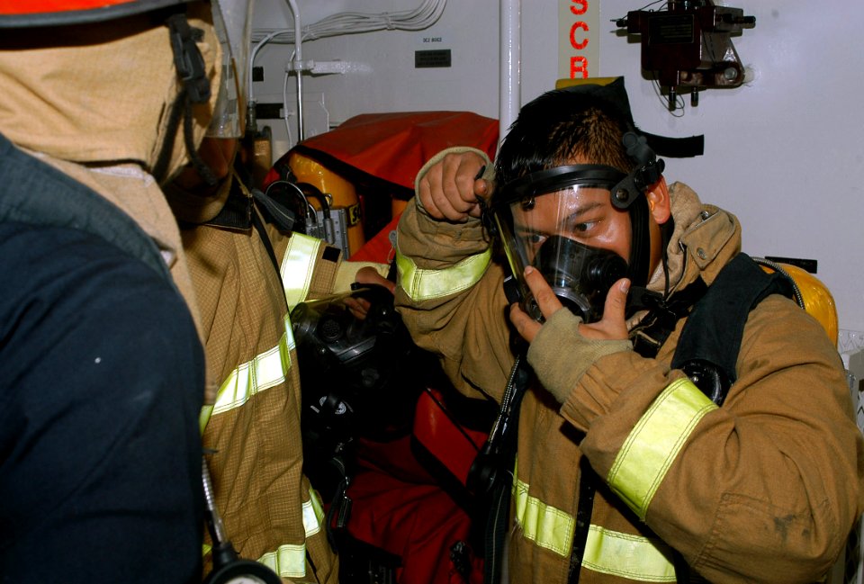 US Navy 071031-N-9123L-001 Interior Communications Electrician 3rd Class Mark Alejandro adjusts the straps on the mask of his self-contained breathing apparatus