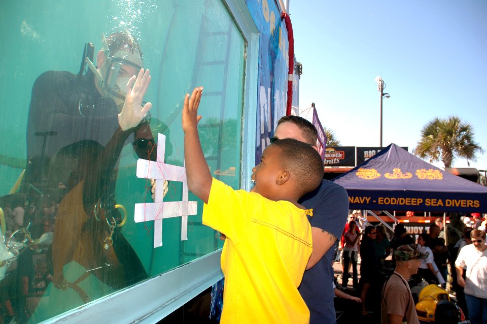 US Navy 071103-N-8102J-094 Equipment Operator Constructionman Apprentice James Figueroa gives a child a high-five