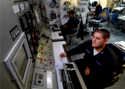 US Navy 071106-N-7981E-172 Gas Turbine Systems Technician (Electrical) 3rd Class Chris Withers monitors the ship's online generators while standing watch at the electrical plant control console in damage control central