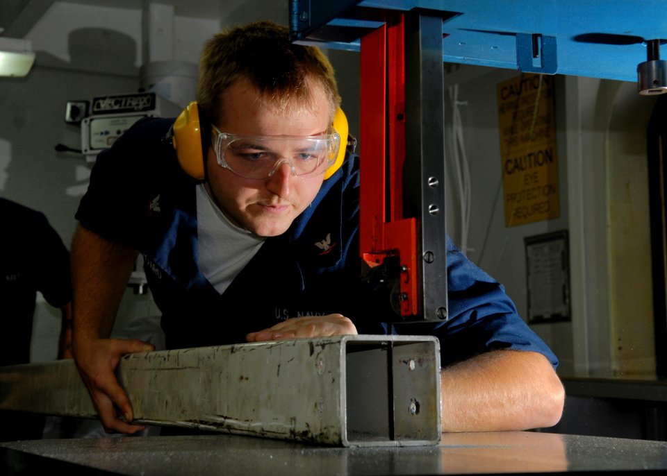 US Navy 071101-N-7981E-023 Aviation Structural Mechanic 3rd Class Christopher Hoard uses a band saw to cut apart a damaged tow bar tongue in the Aviation Intermediate Maintenance Department sheet metal shop aboard Nimitz-class