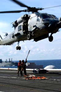 US Navy 071031-N-7883G-038 Sailors assigned to weapons department aboard USS Kitty Hawk (CV 63), prepare to attach excess cables used to transport ammunition and supplies to a HH-60H Seahawk on the carrier's flight deck