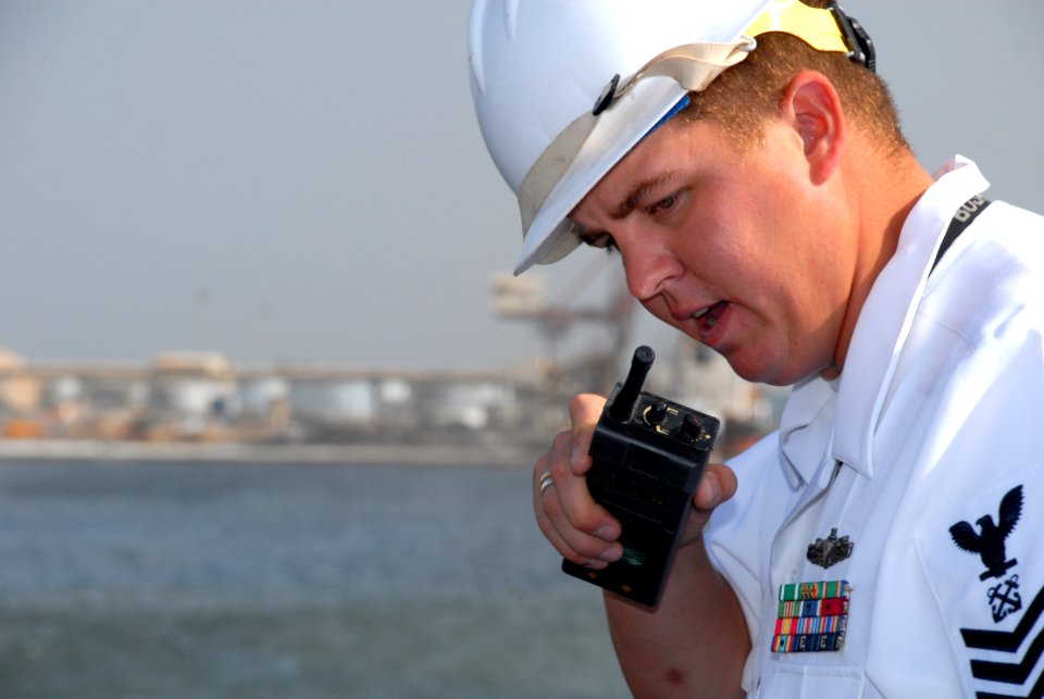 US Navy 071105-N-0193M-500 Boatswain's Mate 1st Class Jay Collette directs line handlers from the flight deck of USS Fort McHenry (LSD 43) during the Africa Partnership Station (APS) arrival in Dakar, Senegal