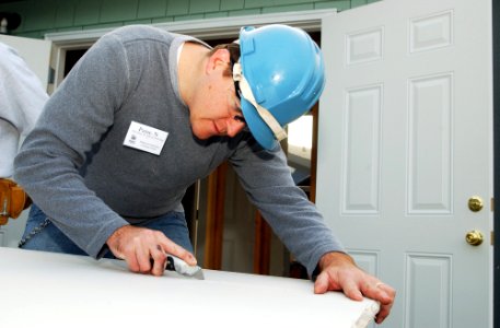 US Navy 071101-N-2143T-002 Machinist's Mate 1st Class Nathaniel Paine, assigned to USS Henry M. Jackson (SSBN 730), cuts and measures dry wall for a Habitat for Humanity volunteer project