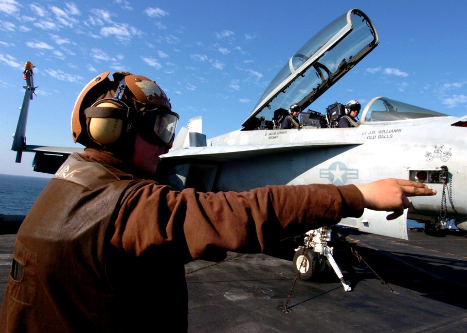 US Navy 071105-N-8132M-018 Aviation Machinist's Mate 3rd Class Russell Clark signals to the pilots during an alert turn that there is a trouble shooter under the aircraft aboard nuclear-powered aircraft carrier USS Enterprise (