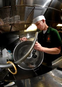 US Navy 071105-N-7981E-315 Boatswain's Mate Seaman Jake Kellner cleans pots and pans in the scullery aboard Arleigh Burke-class guided-missile destroyer USS Shoup