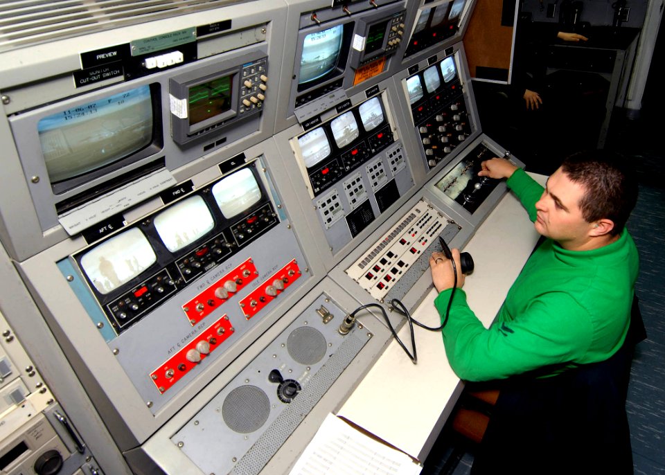 US Navy 071106-N-9898L-006 Interior Communications Electrician 2nd Class Robert Brown operates the camera observation console, part of the Integrated Landing And Recovery Television System, during flight operations