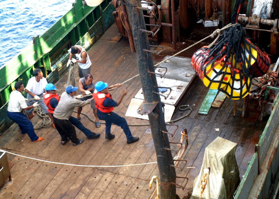 US Navy 071105-N-0000X-009 U.S. Navy Sailors help load lube oil onto Manuvo I prior to it getting underway