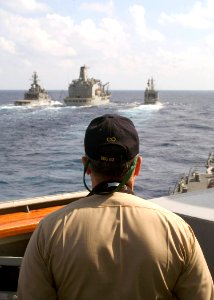 US Navy 071110-N-9520G-005 Cmdr. Daniel P. Dusek, commanding officer of Arleigh Burke-class guided-missile destroyer USS Fitzgerald (DDG 62), looks ahead as his ship maneuvers behind Military Sealift Command underway replenishm