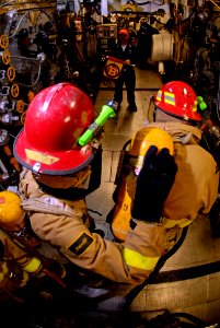US Navy 071110-N-7883G-045 Damage Controlman 3rd Class Heath Neal, left, and Damage Controlman 3rd Class Jonathan Rios fight a simulated fire during a main machinery space fire drill aboard the aircraft carrier USS Kitty Hawk (