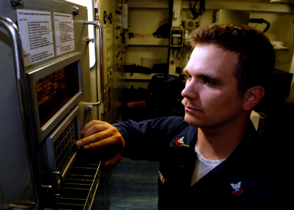 US Navy 071106-N-7981E-089 Electronics Technician 2nd Class Nolan Sobania checks the system configuration on the ship's WSN-7 internal navigation system aboard guided-missile destroyer USS Shoup (DDG 86)