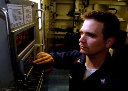 US Navy 071106-N-7981E-089 Electronics Technician 2nd Class Nolan Sobania checks the system configuration on the ship's WSN-7 internal navigation system aboard guided-missile destroyer USS Shoup (DDG 86)