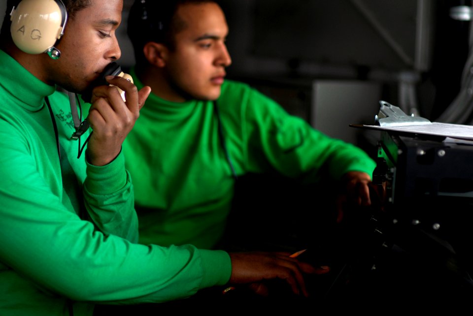 US Navy 071107-N-4776G-209 Aviation Boatswain's Mate (Equipment) 3rd Class Joseph Mustin, from Bristow, Okla., operates a sound powered phone while Interior Communications Electrician 3rd Class Michael Florse, from Los Angeles