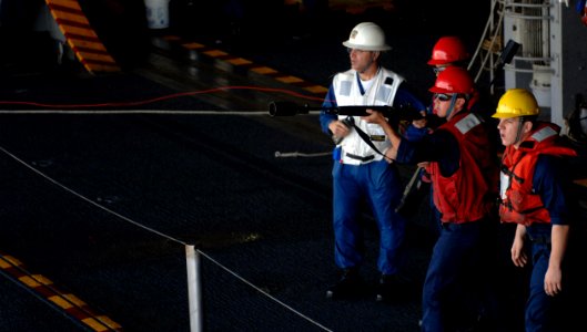 US Navy 071113-N-0455L-001 Gunner's Mate 3rd Class Adam Lindley fires a messenger line with his M-14 rifle over to the Military Sealift Command fleet replenishment oiler USNS Big Horn (T-AO 198) in preparation for a replenishme