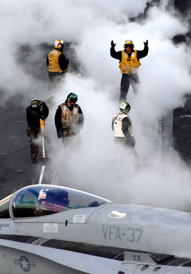 US Navy 071107-N-0455L-006 A plane director gives directional signaling to an F-A-18E Super Hornet in preparation for launch from Nimitz-class aircraft carrier USS Harry S. Truman (CVN 75)