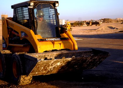 US Navy 071113-N-3857R-013 Construction Electrician 1st Class Daniel Harper, assigned to Naval Mobile Construction Battalion (NMCB) 1, operates a bobcat to clear debris that will allow concrete to be placed to patch one of the