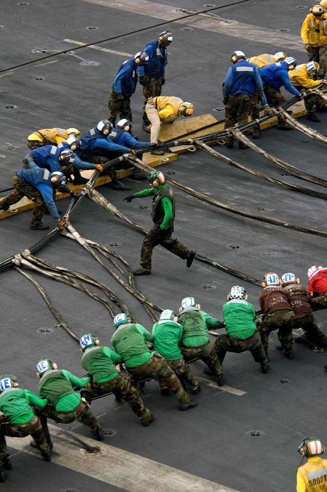 US Navy 071108-N-5387K-030 Flight deck personnel stationed aboard the USS Kitty Hawk (CV 63), set up a aircraft barricade during a safety drill