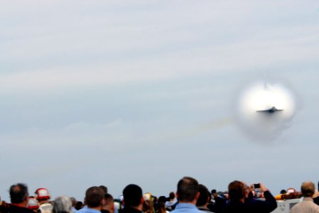 US Navy 071111-N-3659B-102 Spectators look on as an F-A-18E Super Hornet performs a high-speed flyby as part of an air demonstration above Nimitz-class aircraft carrier USS Ronald Reagan (CVN 76)