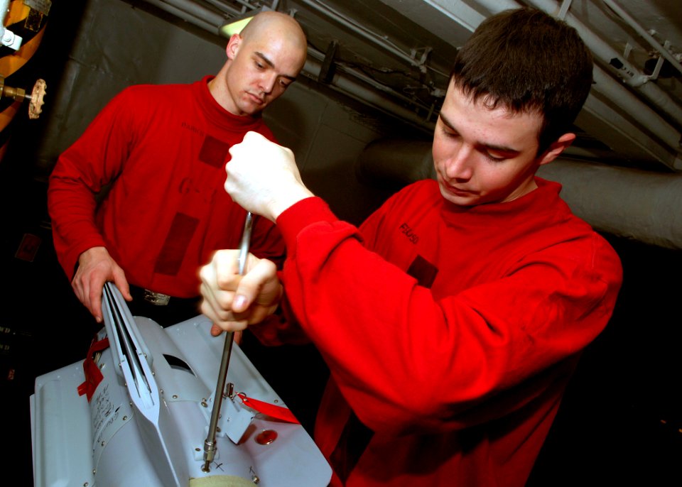 US Navy 071114-N-5928K-002 Aviation Ordnanceman 3rd Class Michael Parks, left, and Aviation Ordnanceman Airman Matthew Ferguson attach the fin to a guided bomb unit (GBU) 12