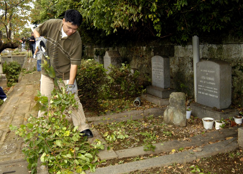 US Navy 071107-N-4649C-005 Culinary Specialist Seaman George Macapagal, stationed on board Commander, Fleet Activities Yokohama Detachment, picks up branches and weeds at the Yamate Gaijin Bochi Cemetery in Yokohama, Japan