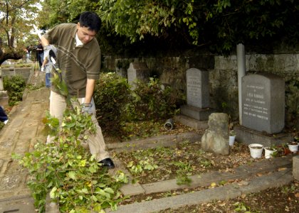 US Navy 071107-N-4649C-005 Culinary Specialist Seaman George Macapagal, stationed on board Commander, Fleet Activities Yokohama Detachment, picks up branches and weeds at the Yamate Gaijin Bochi Cemetery in Yokohama, Japan