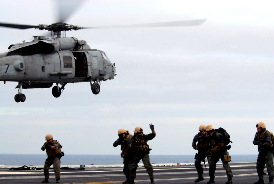 US Navy 071111-N-3659B-411 Members of Mobile Security Squadron 3, Visit Board Search and Seizure detachment, advance across the flight deck as part of an air demonstration