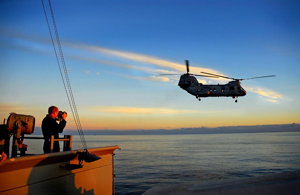 US Navy 071108-N-4774B-087 Mass Communication Specialist Seaman Jon Husman photographs a CH-46 Sea Knight as it takes off from the flight deck of amphibious assault ship USS Tarawa (LHA 1)