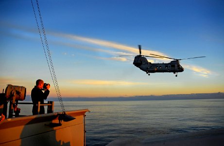 US Navy 071108-N-4774B-087 Mass Communication Specialist Seaman Jon Husman photographs a CH-46 Sea Knight as it takes off from the flight deck of amphibious assault ship USS Tarawa (LHA 1)