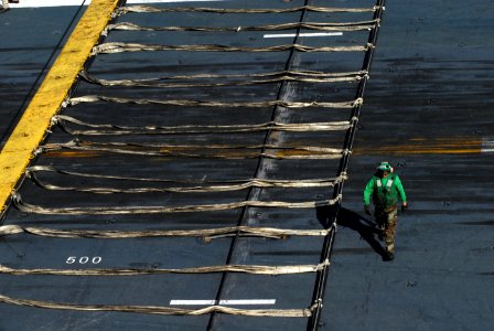 US Navy 071109-N-1688B-050 A Sailor returns to his station after lowering the aircraft barricade on board Nimitz-class aircraft carrier USS Harry S. Truman (CVN 75)