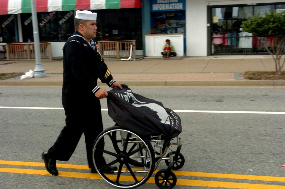 US Navy 071112-N-6676S-011 Aviation Structural Mechanic (Equipment) 1st Class Emmanuel G. Leyaog, a recruiter from Naval Recruit Depot, Richmond, Va., walks the POW-MIA flag draped over a wheelchair during the 2007 Tidewater Ve