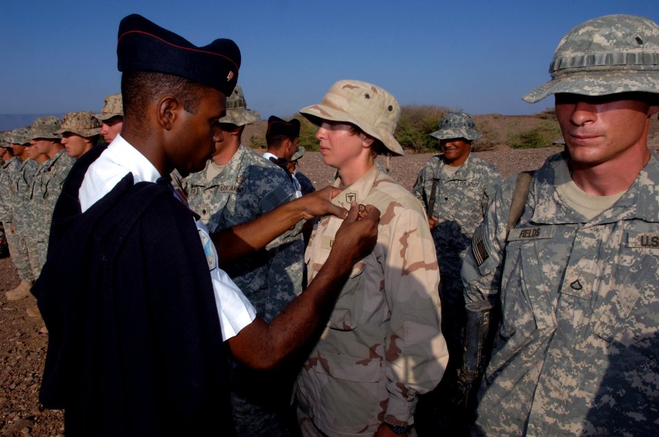 US Navy 071113-N-3931M-030 An instructor from the French military pins a survival badge on U.S. Navy Hospital Corpsman 3rd Class Gwendolyn Collver, assigned to Combined Joint Task Force-Horn of Africa, upon completion of a dese