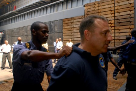 US Navy 071115-N-0193M-150 Nigerian Lt. A.S. Omotosho practices restraining suspects with the help of Coast Guard Chief Boatswain's Mate Anthony Cirillo