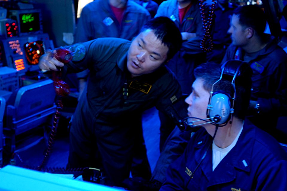 US Navy 071114-N-7883G-019 Lt.j.g. Eric Steidle discuss anti-submarine warfare tactics with a liaison officer of the Japan Maritime Self-Defense Forces (JMSDF) to facilitate the communication between JMSDF assets