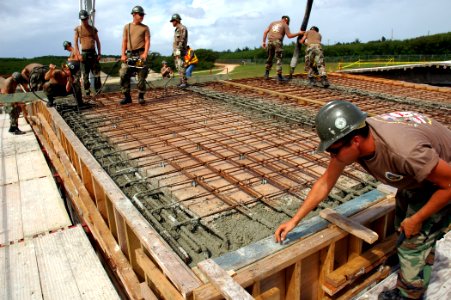 US Navy 071121-N-7367K-002 Seabees with U.S. Naval Mobile Construction Battalion (NMCB) 1, Guam Det., began laying concrete in one section of the roof of the Orote Point concrete masonry unit-block mechanics' shop on board Nava