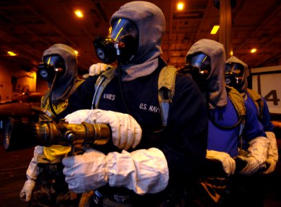 US Navy 071116-N-8923M-016 A fire party battles a simulated fire in the hangar bay during a general quarters drill aboard the Nimitz-class nuclear-powered aircraft carrier USS Harry S. Truman (CVN 75)