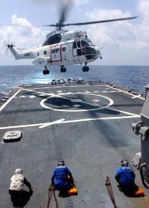 US Navy 071124-N-4014G-021 Sailors stationed aboard the guided-missile destroyer USS Porter (DDG 78) wait for a helicopter from the Military Sealift Command dry cargo-ammunition ship USNS Lewis and Clark (T-AKE 1) to land for a