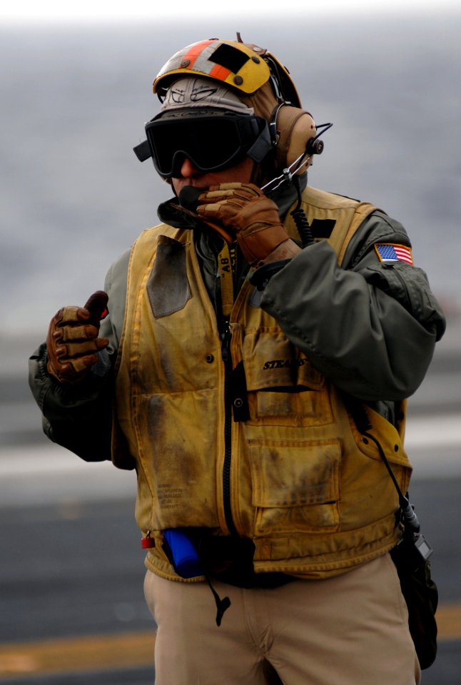 US Navy 071117-N-8923M-247 Chief Aviation Boatswain's Mate (Handling) Martin Jimenez speaks into his headset during flight operations aboard the Nimitz-class nuclear-powered aircraft carrier USS Harry S. Truman (CVN 75)