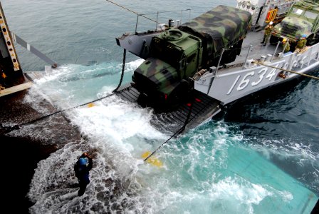 US Navy 071115-N-6936D-085 Sailors from amphibious transport dock ship USS Juneau (LPD 10) perform a stern gate mairige with a landing craft utility to off load two, seven-ton trucks from Juneau