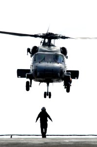 US Navy 071126-N-3136P-045 A Sailor signals a Helicopter Anti-Submarine Squadron (HS) 14 SH-60F Seahawk to take off from the flight deck of the aircraft carrier USS Kitty Hawk (CV 63)