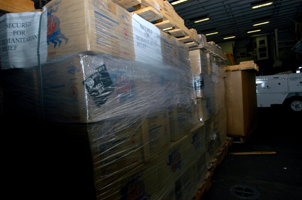 US Navy 071126-N-3173B-009 Pallets of water and hygiene supplies await transport in the hangar bay aboard amphibious assault ship USS Kearsarge (LHD 3)