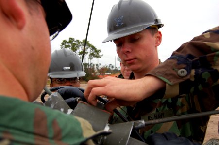 US Navy 071127-N-1057H-693 Electronics Technician 3rd Class Johnathon Cooper, attached to the Naval Mobile Construction Battalion (NMCB) 11 communications platoon, demonstrates the assembly of an OE-254-GRC antennae during NM