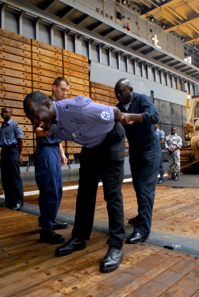 US Navy 071115-N-0193M-108 Nigerian Petty Officer James Ma allows Nigerian Petty Officer Ameh AJ to practice hand cuffing during an officer-boarding course taught by the U.S. Coast Guard International Training Division