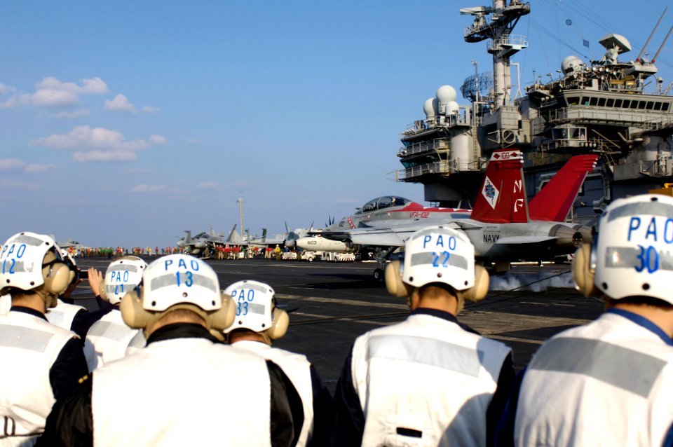 US Navy 071115-N-7883G-050 Japan Self-Defense Forces personnel watch a Strike Fighter Squadron (VFA) 102 F-A-18F Super Hornet land on the flight deck aboard the aircraft carrier USS Kitty Hawk (CV 63)
